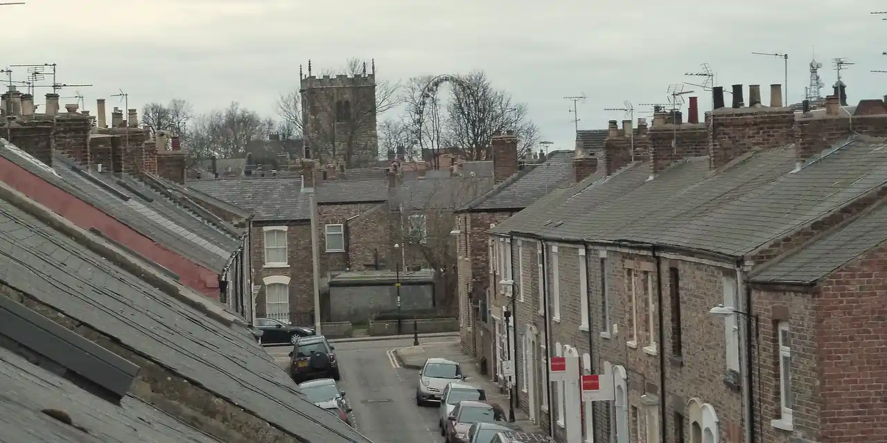 Victorian red-brick terraced houses with Welsh slate roofs and chimney stacks on Kyme Street, York, seen from roof level