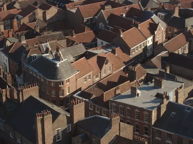 Aerial view over York city-centre roofs: red clay pantiles, grey slate and brick chimney stacks